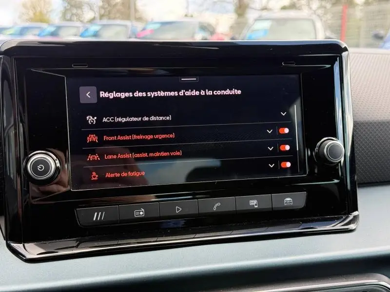 Vue intérieure centrée sur l'écran tactile du tableau de bord du SEAT Arona 2025, affichant les réglages d'aide à la conduite.