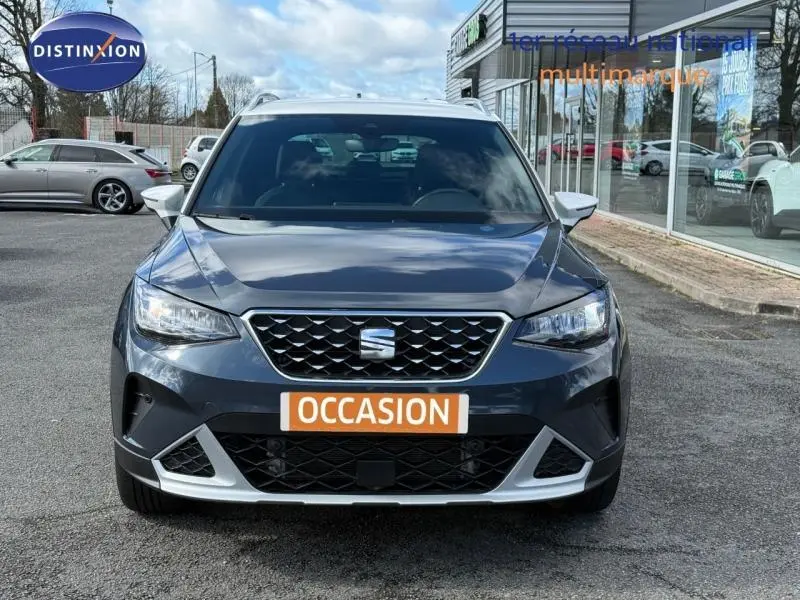 Vue avant d'un SEAT Arona 2025 bleu saphir métal avec toit blanc, mettant en valeur sa calandre et ses optiques LED.