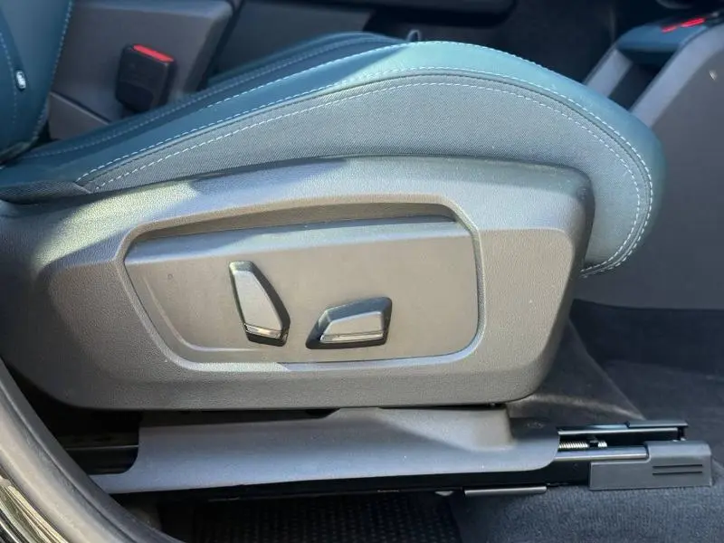 Gros plan sur les commandes de réglage électrique du siège côté conducteur du MINI Countryman 2024 en Midnight Black II.