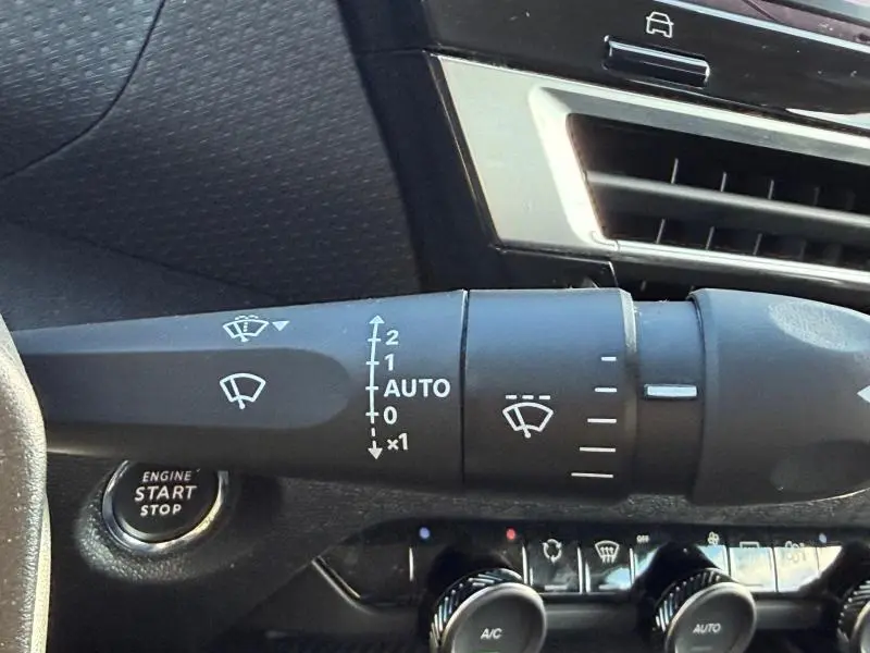 Gros plan sur la commande d’essuie-glace côté droit dans l’habitacle noir du Citroën C4 X 2024, avec bouton start/stop visible.