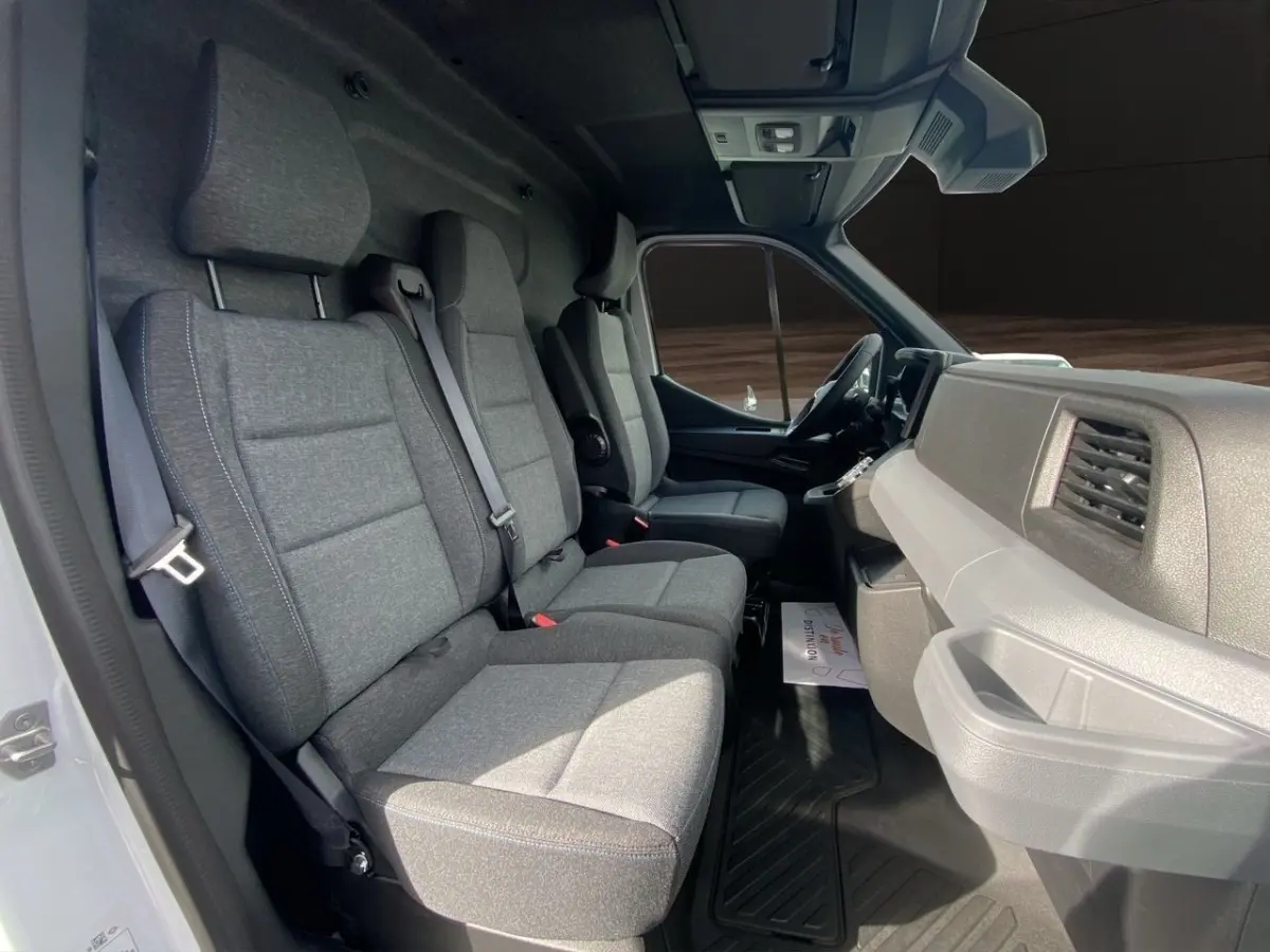 Vue intérieure côté conducteur du Renault Master 2025, montrant les sièges gris et le tableau de bord clair.