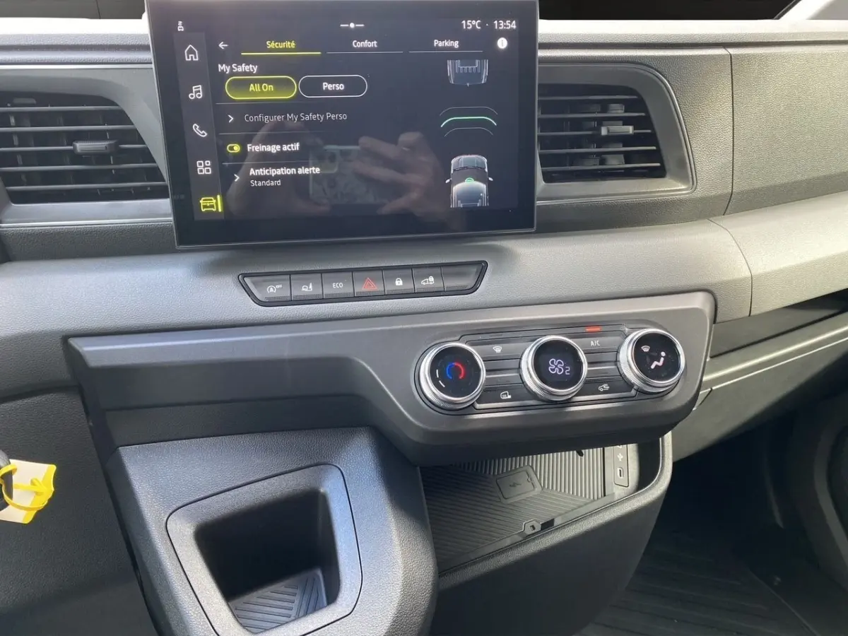 Vue intérieure du tableau de bord du Renault Master blanc 2025 avec écran tactile et commandes de climatisation.