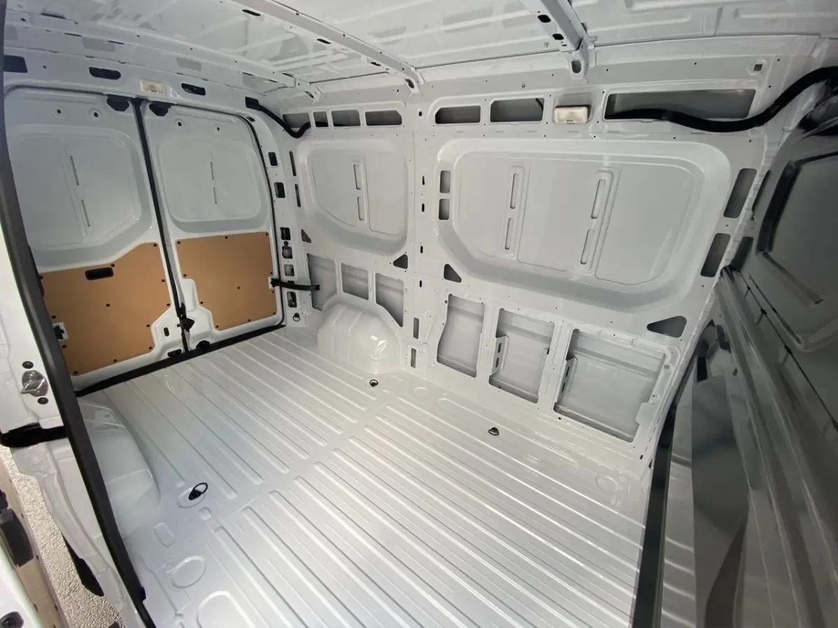 Intérieur du compartiment de chargement blanc du Renault Master FG L2H2, vue depuis l'arrière vers l'avant avec portes ouvertes.