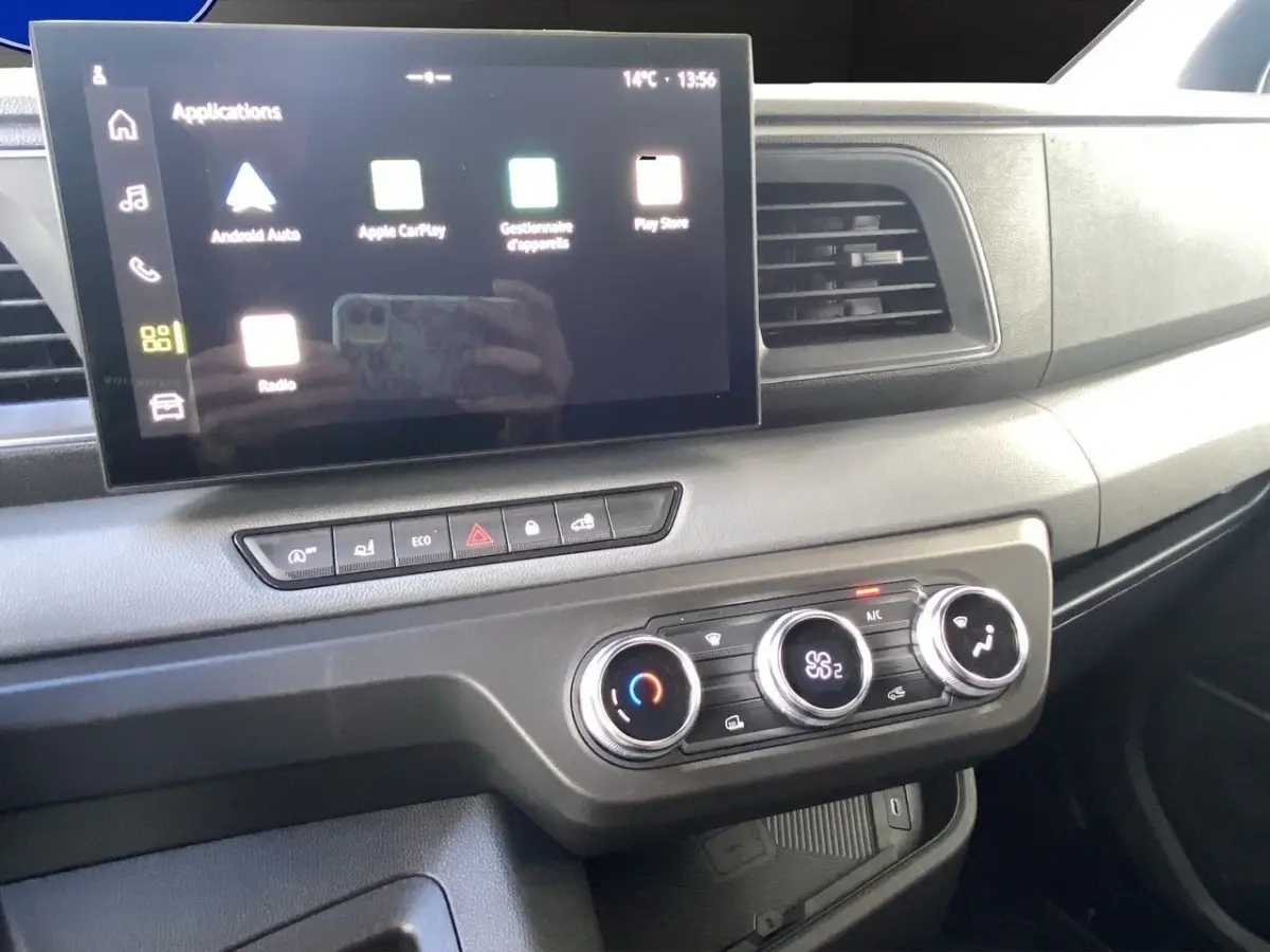 Vue rapprochée du tableau de bord du Renault Master 2025, avec écran tactile et commandes de climatisation visibles.