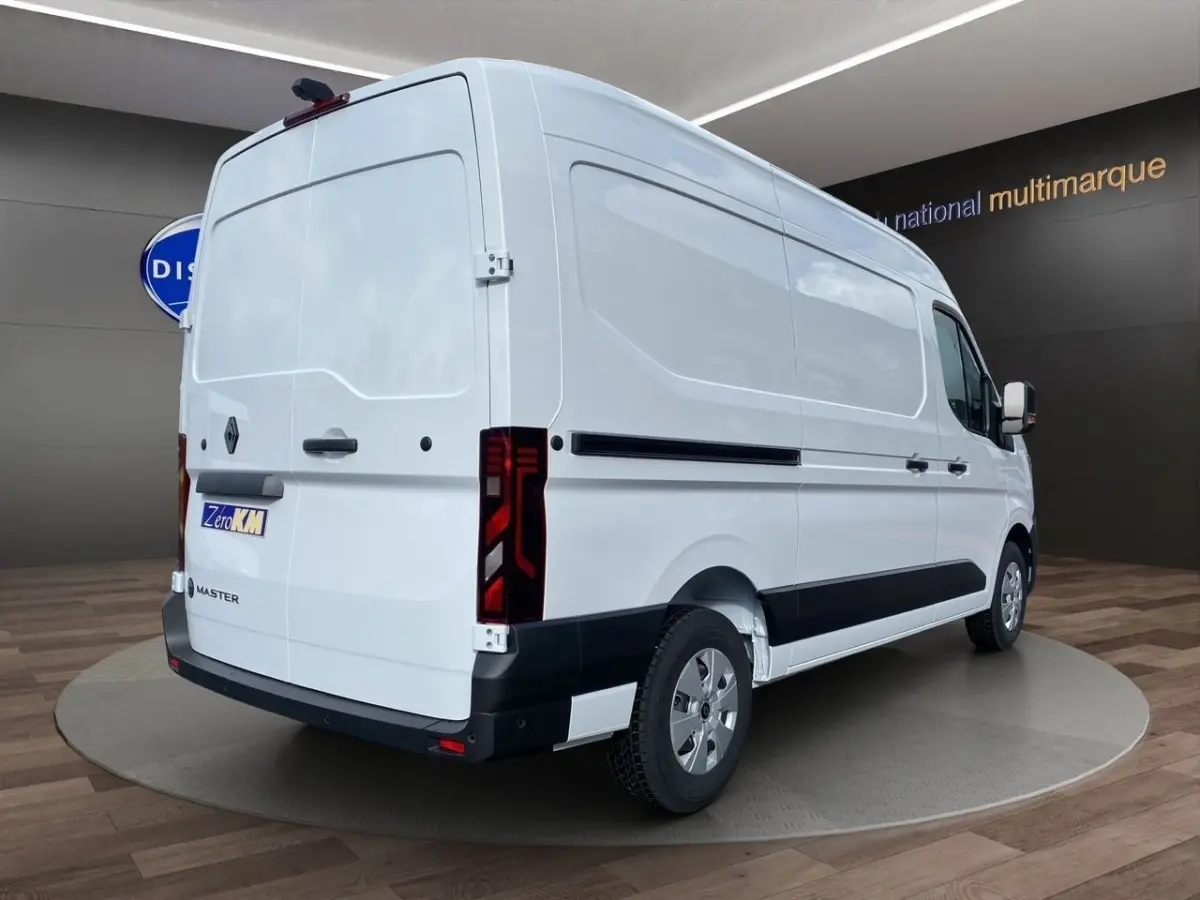 Vue 3/4 arrière droite du Renault Master blanc avec feux arrière LED et protections latérales noires.