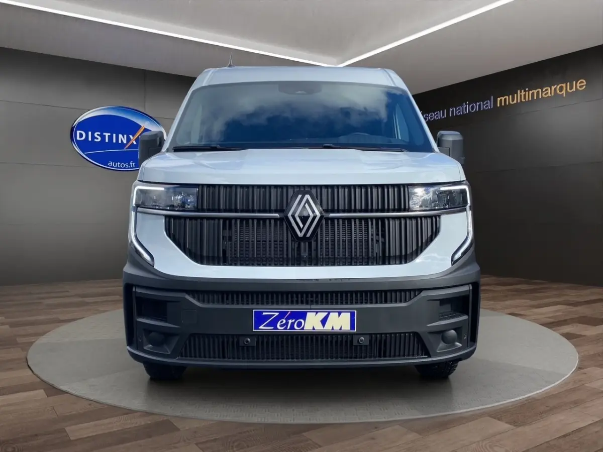 Vue frontale d’un Renault Master blanc 2025 avec calandre noire verticale et phares LED intégrés, plaque Zéro KM visible.