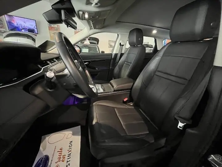 Intérieur noir cuir du Range Rover Evoque II vu côté conducteur, avec tableau de bord et volant visibles.