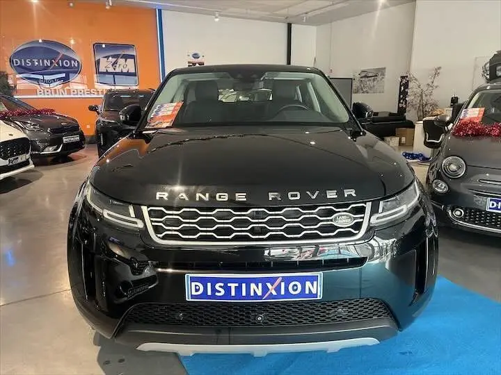 Vue frontale d'un Range Rover Evoque noir Santorini exposé en showroom avec plaque Distinxion visible.