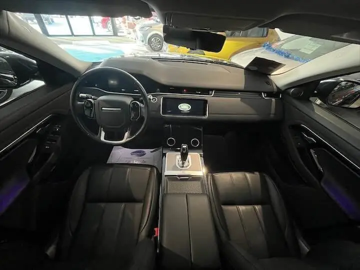 Vue intérieure frontale du Range Rover Evoque noir Santorini, mettant en valeur le tableau de bord moderne et les sièges en cuir Ebony.