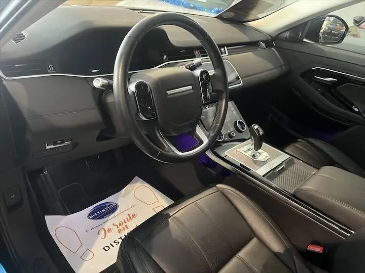 Intérieur noir du Range Rover Evoque 2020 vu côté conducteur, avec volant cuir et console centrale moderne.