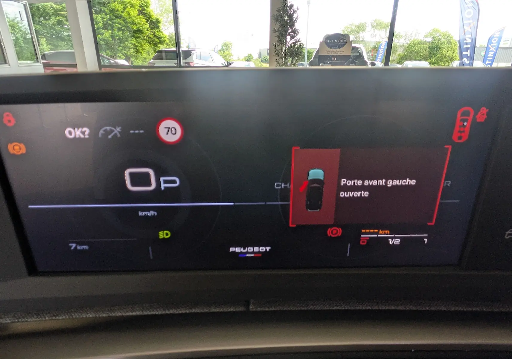 Affichage numérique du tableau de bord du Peugeot 5008 blanc, indiquant porte avant gauche ouverte et vitesse à 0 km/h.