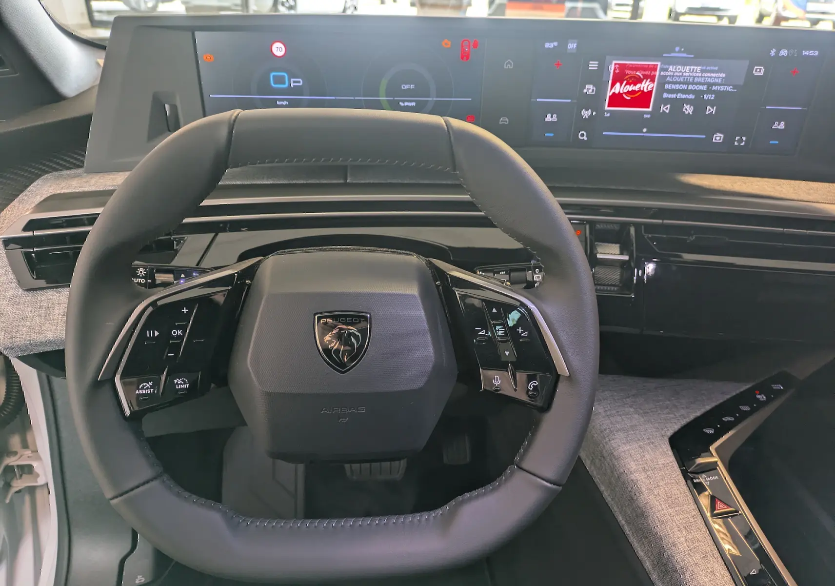 Vue intérieure centrée sur le volant noir du Peugeot 5008 2025 avec double écran HD suspendu et tableau de bord numérique.