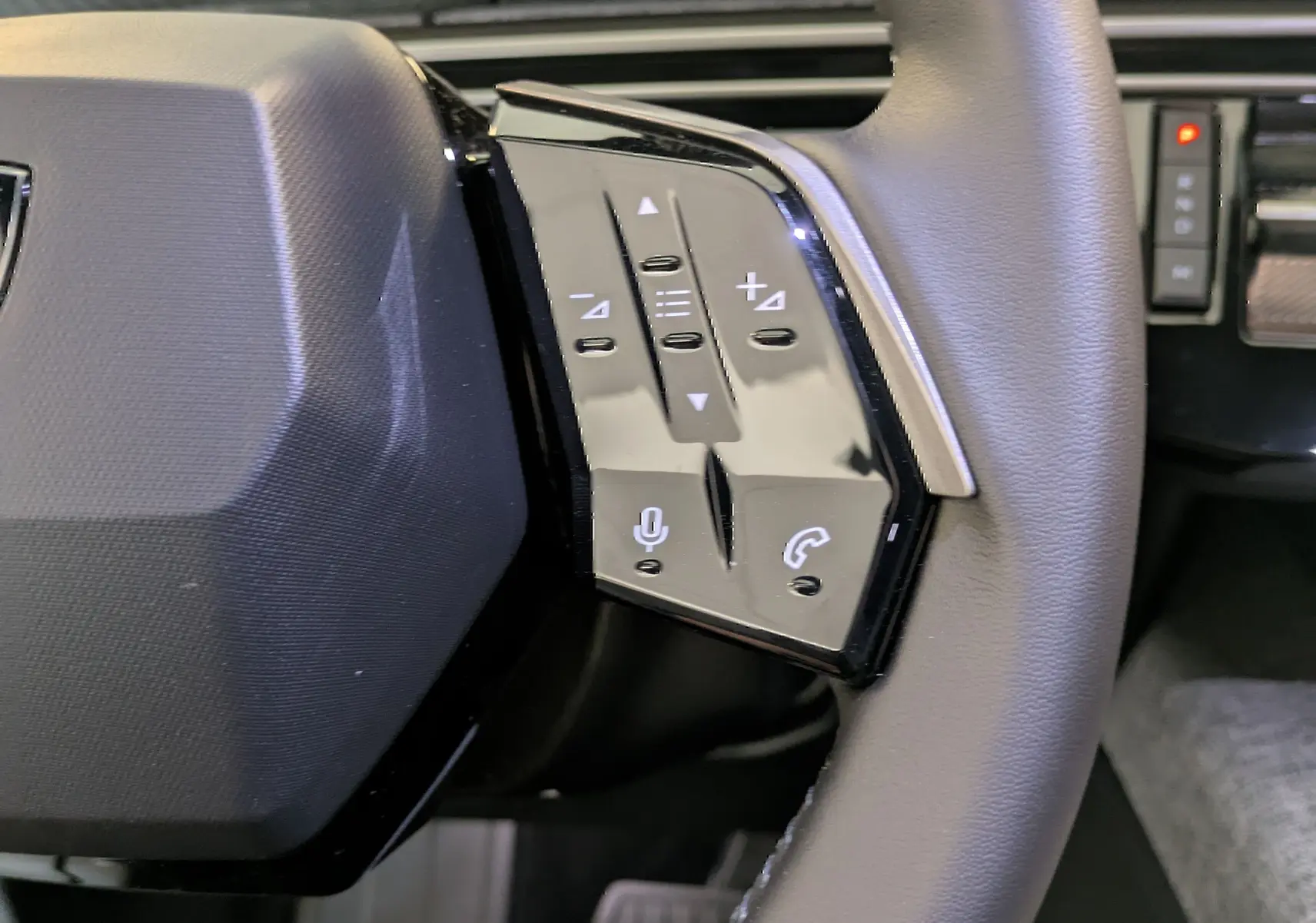 Gros plan sur la partie droite du volant du Peugeot 5008 2025, avec commandes vocales et téléphone intégrées.