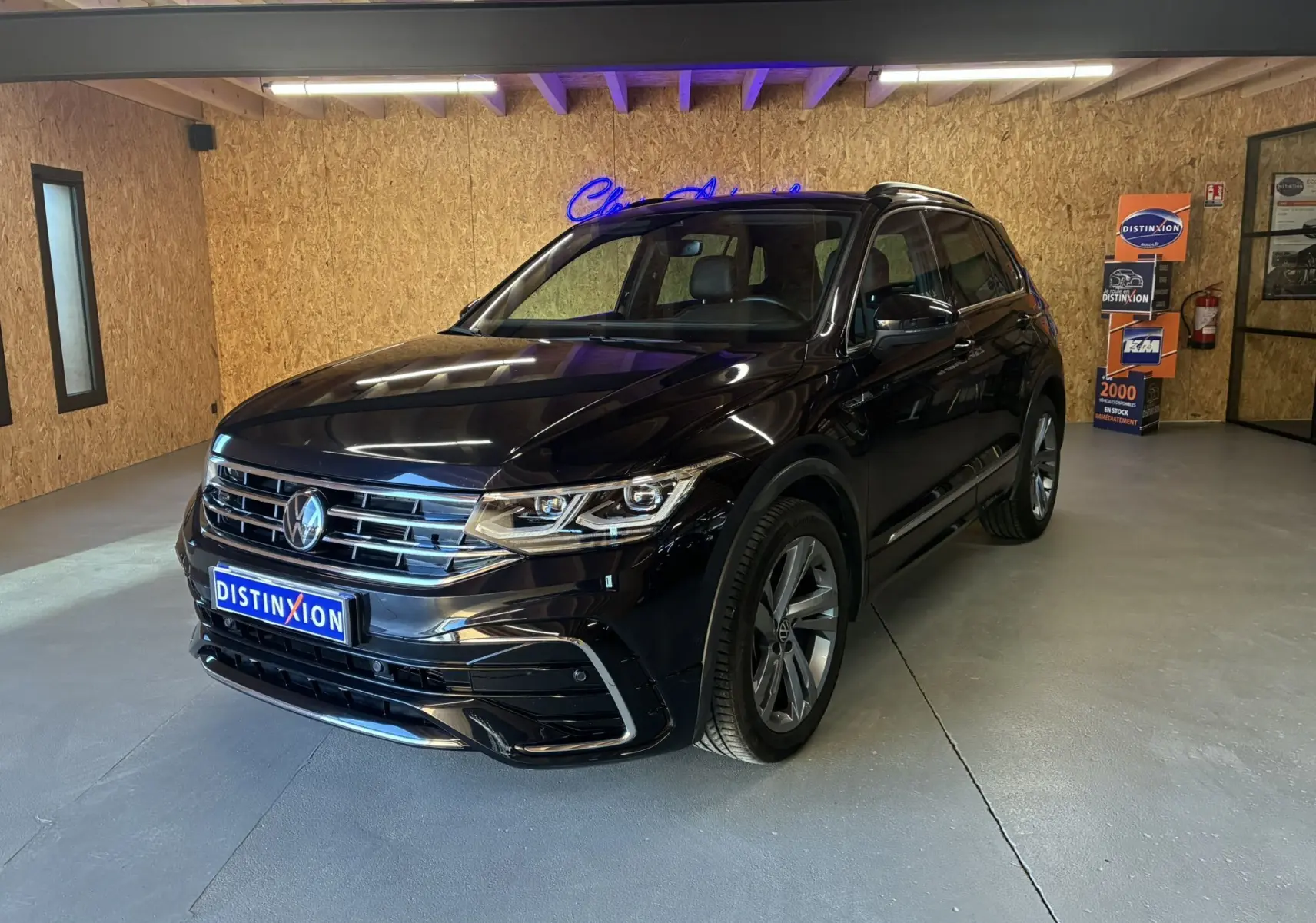Volkswagen Tiguan noir en 3/4 avant droit dans un showroom avec jantes alu et calandre chromée.