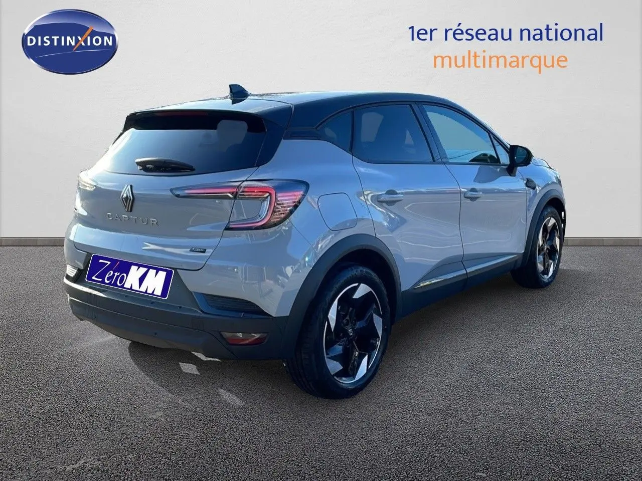 Vue 3/4 arrière droite d'un Renault Captur E-Tech hybride gris Rafale métal avec toit noir et jantes bicolores.