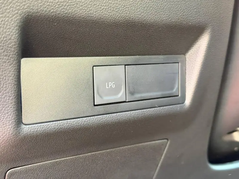 Gros plan sur le bouton LPG noir intégré dans le tableau de bord intérieur du Renault Captur 2025.