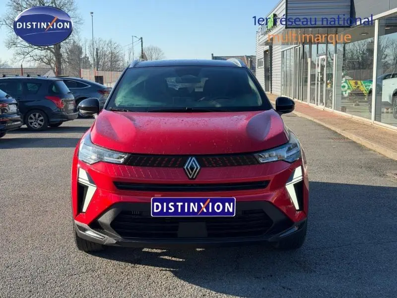 Vue avant du Renault Captur 1.0 Eco-G 100ch Techno 2025 en Rouge Flamme avec toit Noir Etoilé, calandre et feux LED distinctifs.