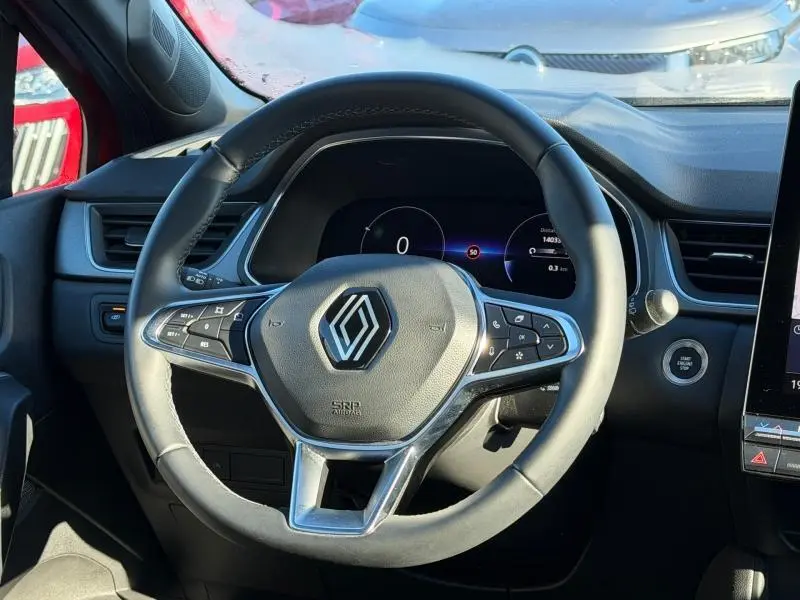 Vue rapprochée du volant multifonction noir du Renault Captur 2025, avec tableau de bord numérique en arrière-plan.