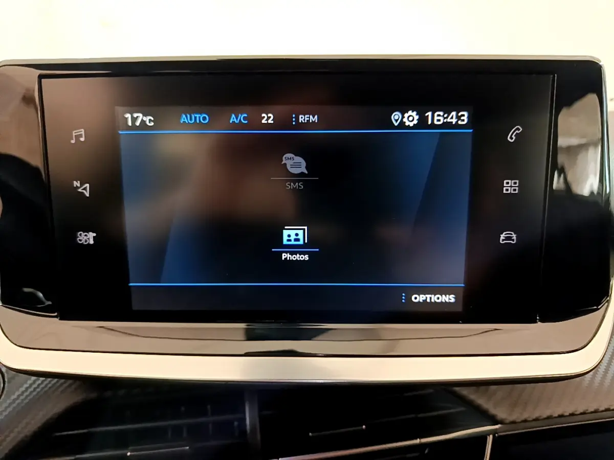 Écran tactile central du tableau de bord de la Peugeot 2008 gris foncé, affichant les options multimédia et climatisation.