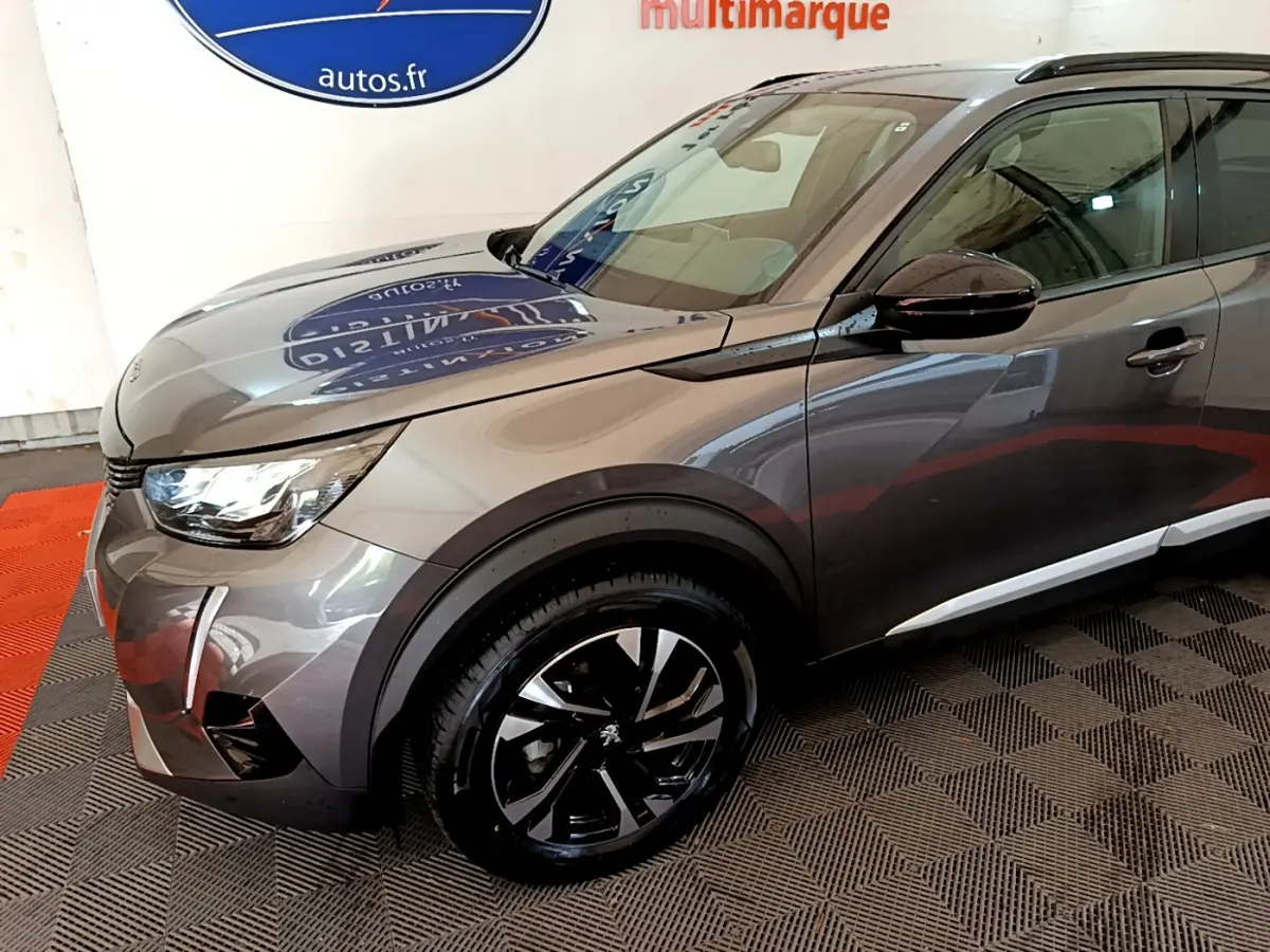 Vue 3/4 avant droit d’un Peugeot 2008 gris foncé avec jantes alliage noires et phares LED ellipsoïdaux.