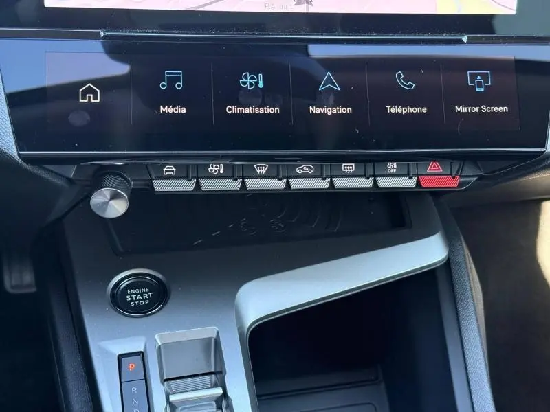 Vue rapprochée de la console centrale de la Peugeot 308 gris 2025, montrant l’écran tactile et les commandes hybrides.