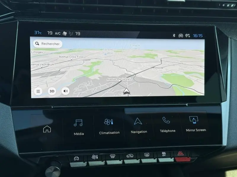 Écran tactile central du tableau de bord du Peugeot 308 gris 2025, affichant la navigation et commandes multimédia.