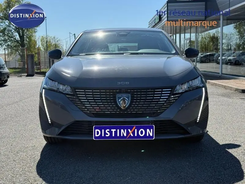 Vue frontale d'une Peugeot 308 gris métallisé 2025 avec calandre noire et feux LED verticaux distinctifs.