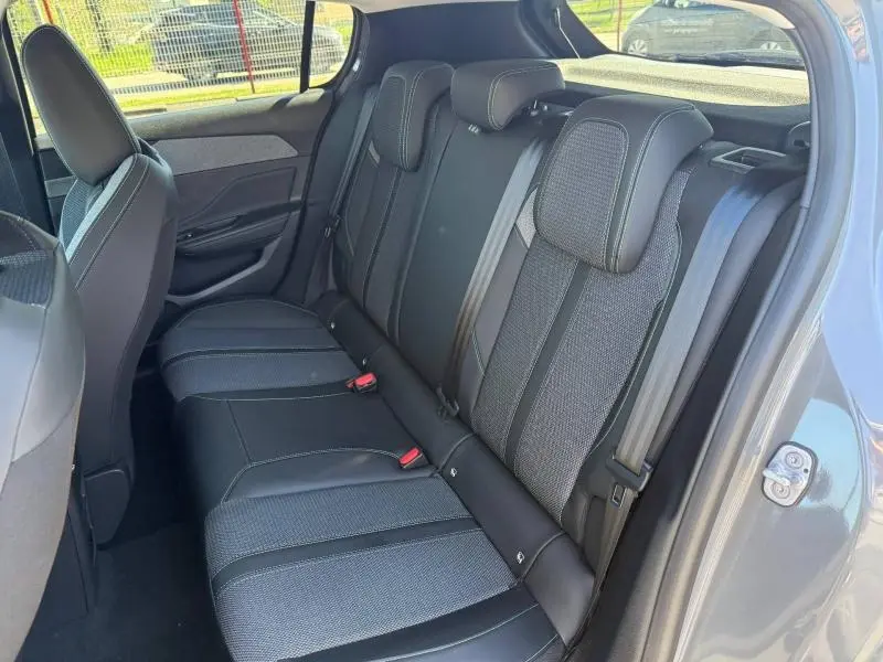 Vue intérieure côté droit des sièges arrière en tissu et cuir noir de la Peugeot 308 1.2 Hybrid 145ch Allure 2025 gris.