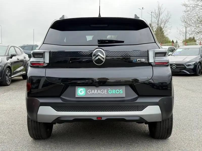 Vue arrière d'une Citroën C3 électrique 2025 en Noir Perla Nera avec logo central et bande noire distinctive.