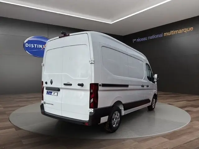 Renault Master blanc en vue 3/4 arrière droit, fourgon utilitaire avec feux arrière verticaux et jantes acier.