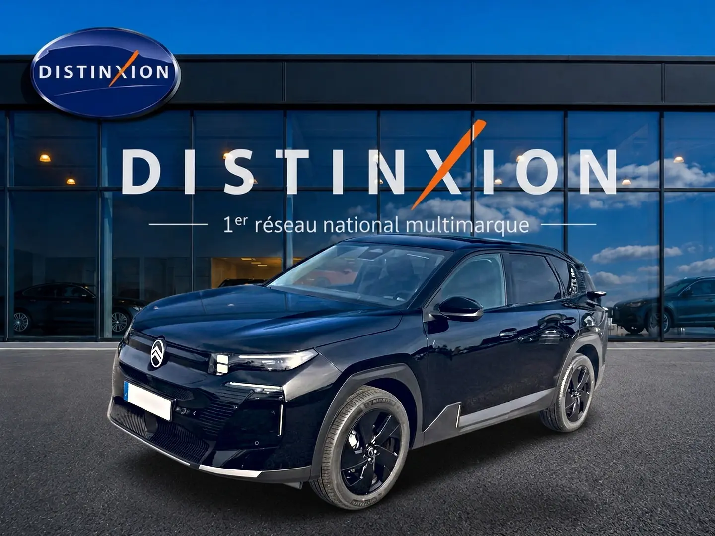 Vue 3/4 avant d'un Citroën C5 Aircross noir 2026 avec jantes noires, devant une vitrine Distinxion.