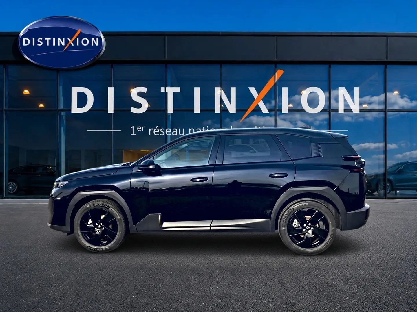 Profil côté gauche du Citroën C5 Aircross noir 2026, avec jantes noires et lignes modernes devant une vitrine Distinxion.