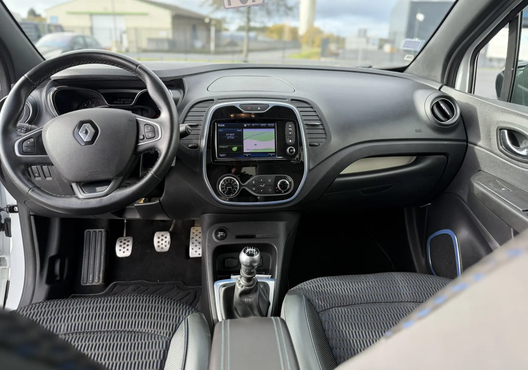 Intérieur du Renault Captur blanc 2017, vue de face sur le tableau de bord avec écran tactile et levier de vitesse manuel.