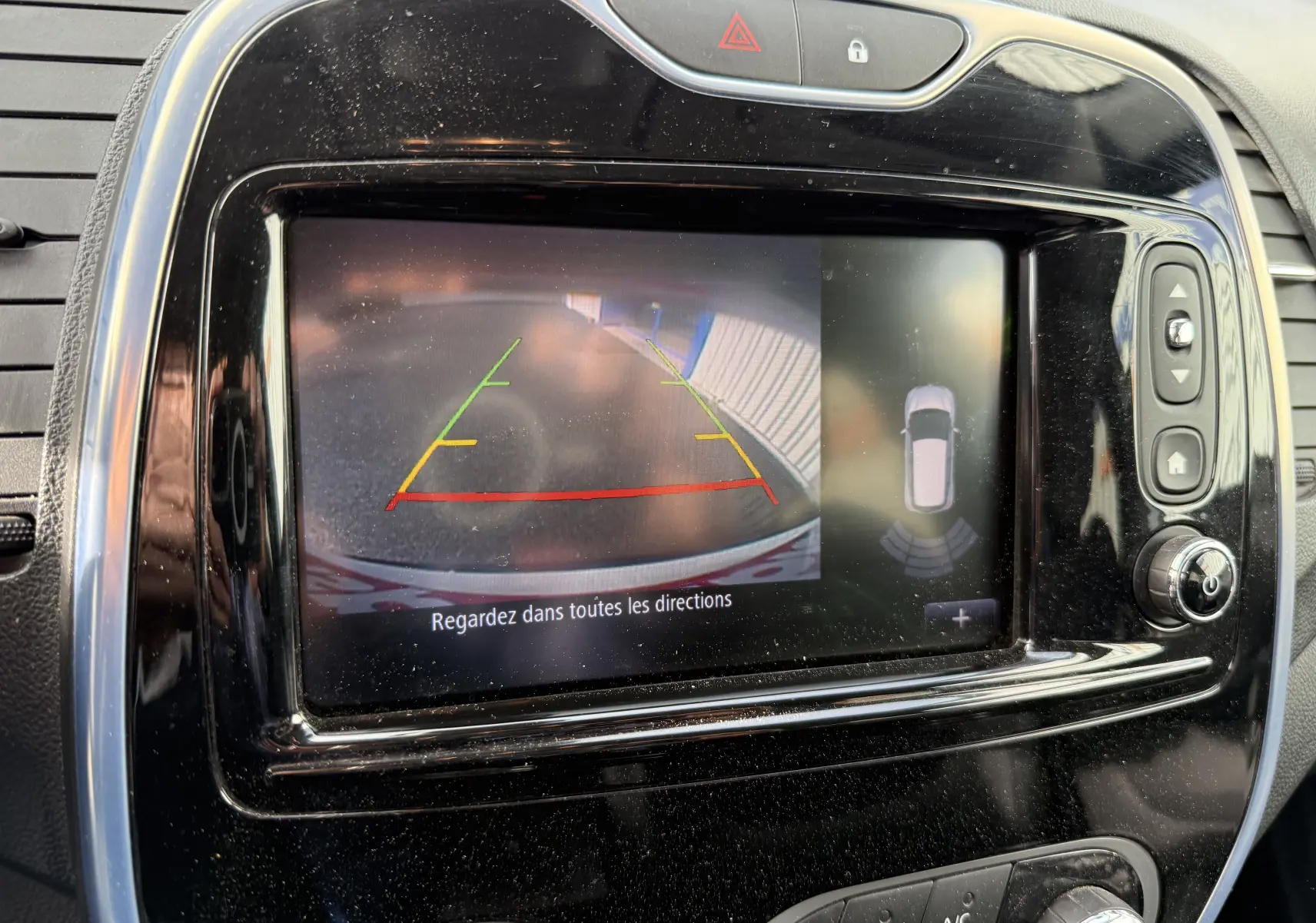 Écran central de Renault Captur blanc 2017 montrant la caméra de recul avec lignes de guidage colorées et vue 360° du véhicule.