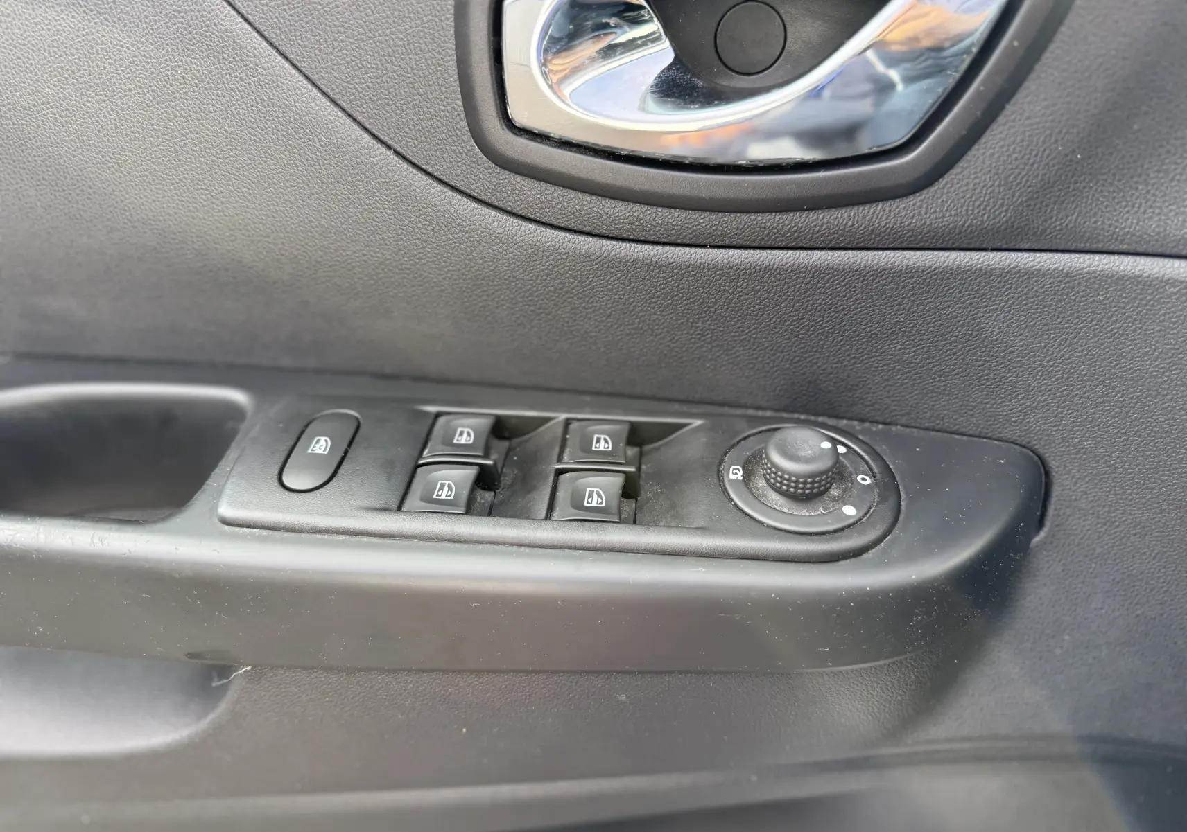 Gros plan sur la commande des vitres électriques et réglage des rétroviseurs côté gauche d'une Renault Captur blanc 2017.