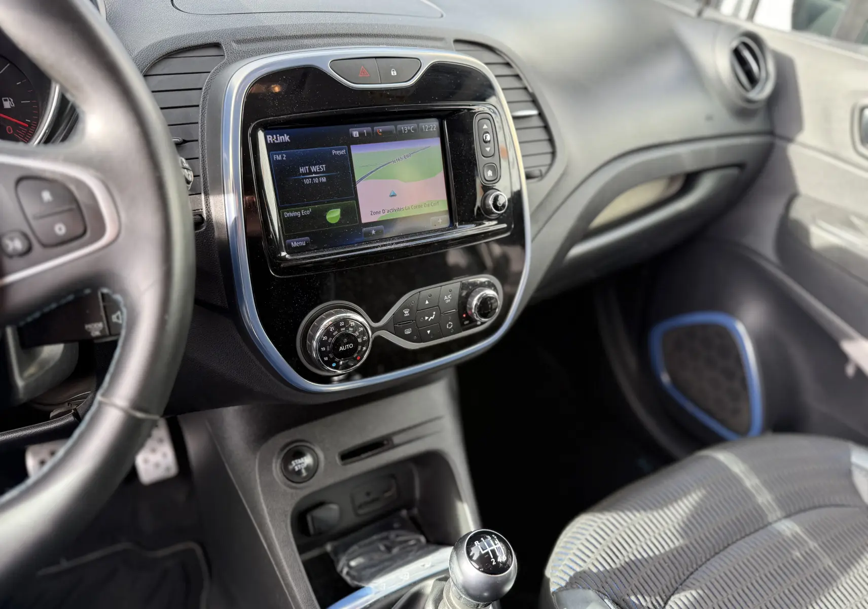 Intérieur Renault Captur blanc 2017, vue côté conducteur sur tableau de bord avec écran tactile et levier de vitesse manuel.