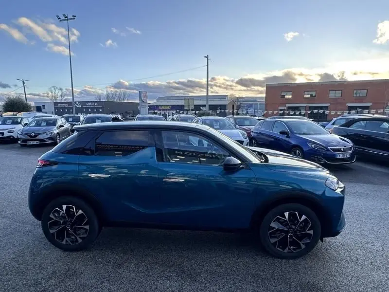 Vue de profil côté gauche d'une DS3 1.2 Hybride 145 Étoile bleu métal, avec jantes noires au design distinctif.
