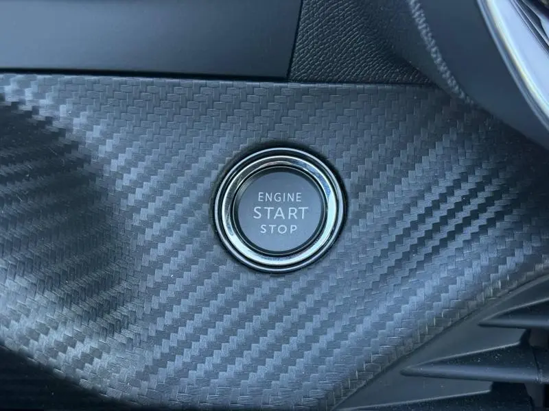 Bouton poussoir "Engine Start Stop" sur tableau de bord en finition carbone du Peugeot 2008 hybride 2025.