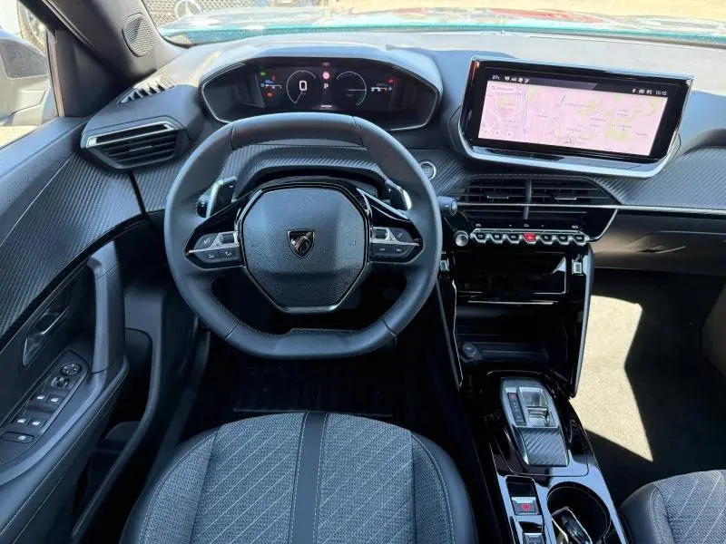 Vue intérieure centrée sur le volant et le tableau de bord numérique du Peugeot 2008 Hybrid 2025 en finition Allure.