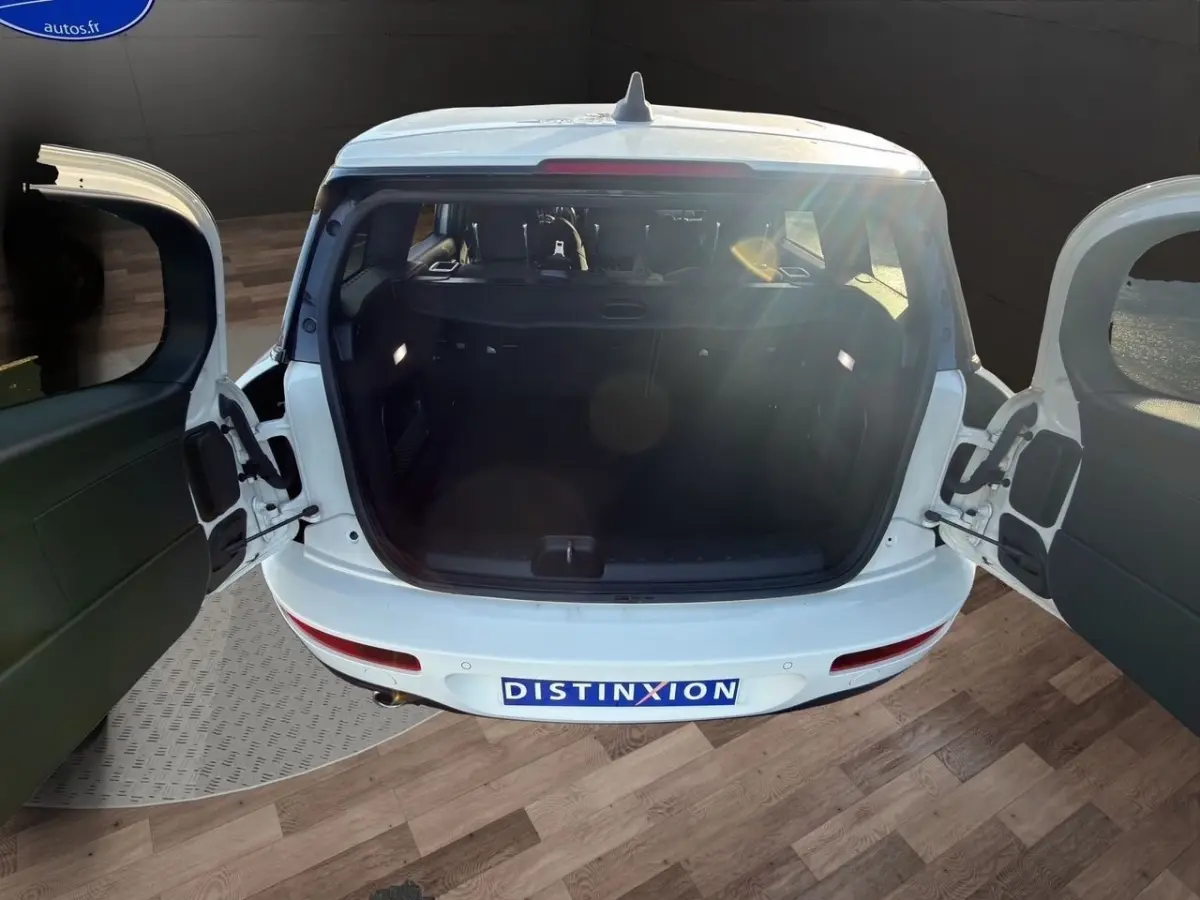 Vue arrière du coffre ouvert d'une MINI Clubman F54 blanche, montrant les portes battantes et l'espace de chargement vide.