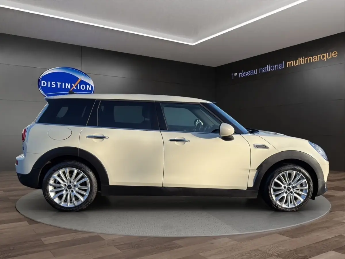 Vue de profil côté gauche d'une MINI Clubman Cooper Exquisite blanche avec toit blanc et jantes alliage.