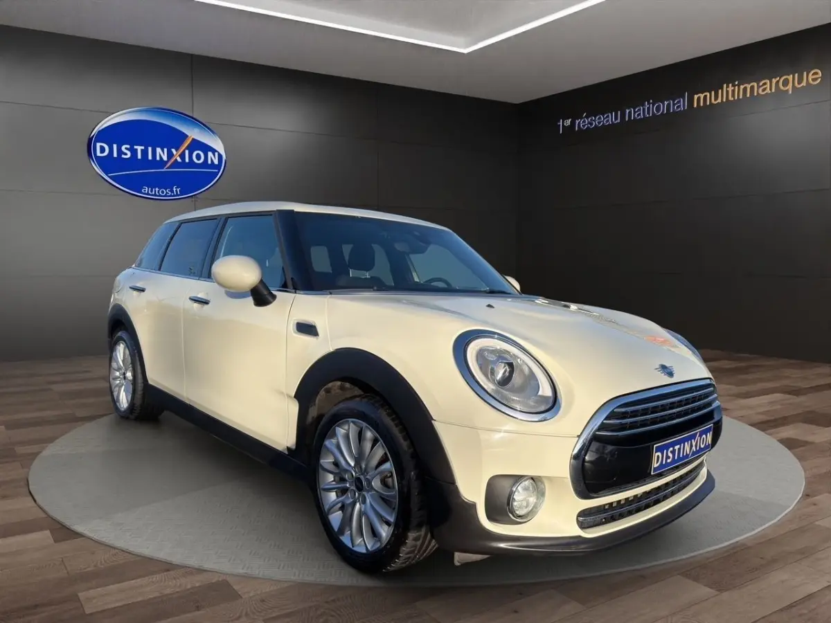 MINI CLUBMAN Cooper Exquisite blanc vue 3/4 avant droit, avec phares ronds et calandre chromée distinctive.