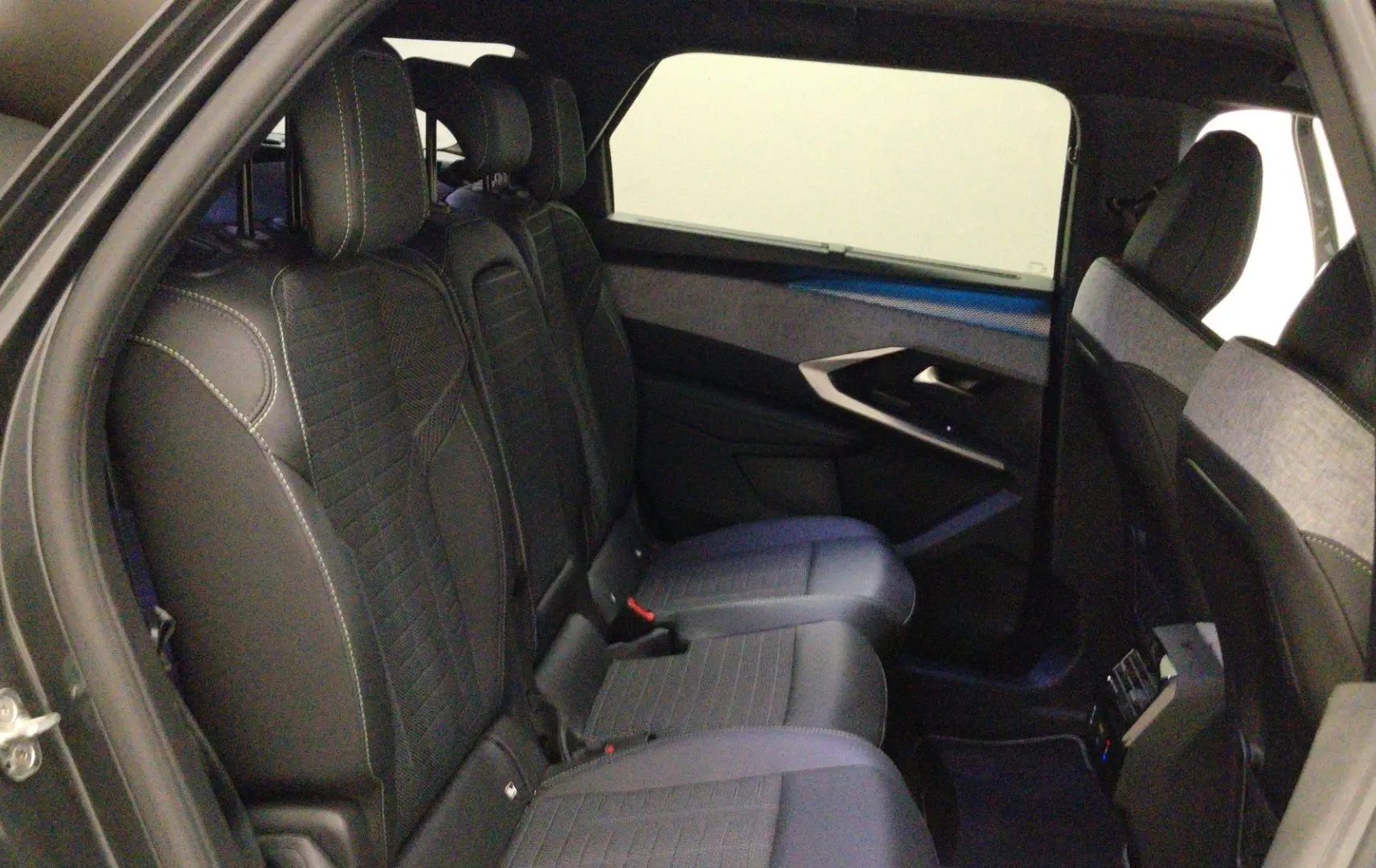 Vue intérieure côté droit des sièges arrière en cuir noir avec surpiqûres blanches du Peugeot 5008 III Hybrid 145 e-DCS6 GT.