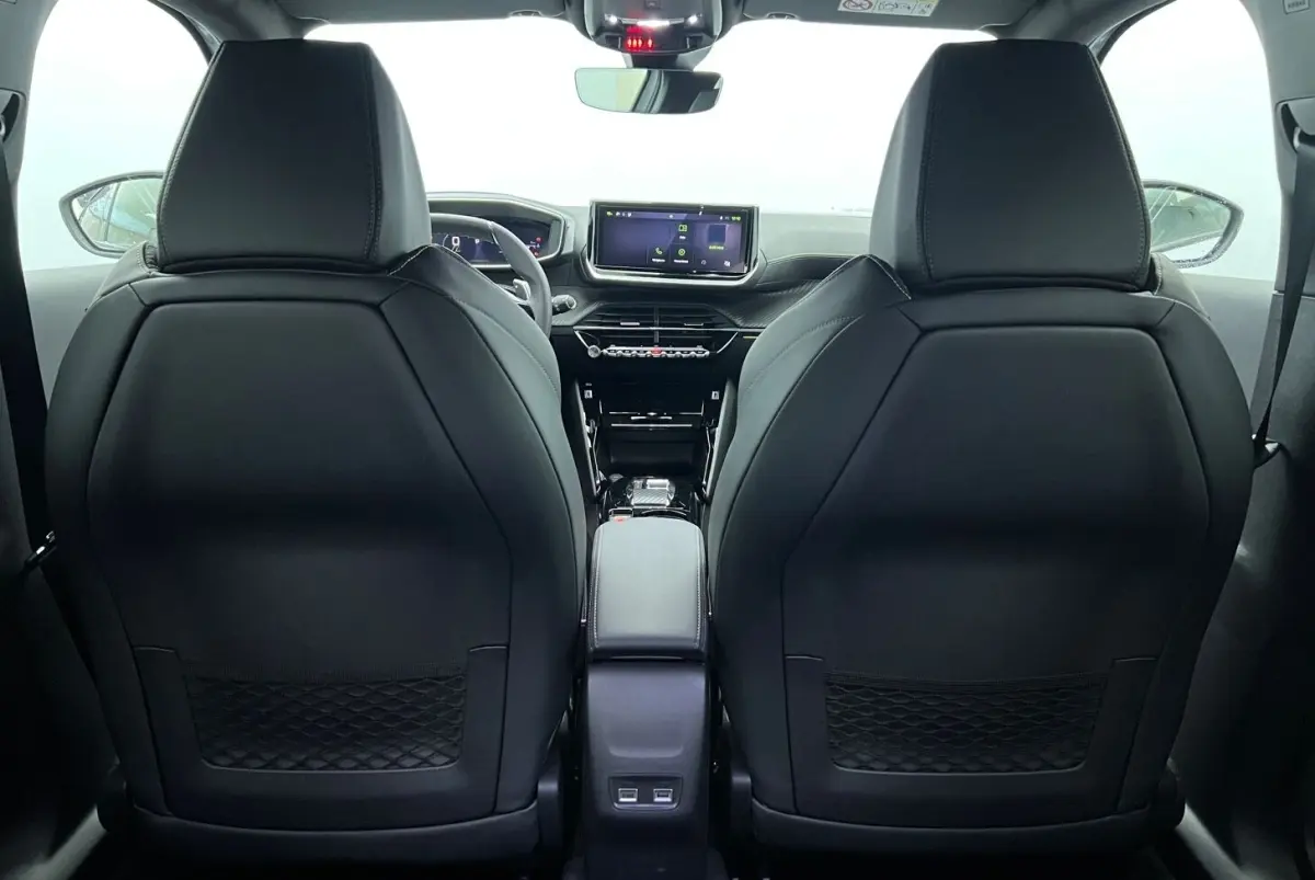 Vue arrière de l’intérieur noir du Peugeot 2008 Hybrid 145 GT, avec écran tactile central et sièges avant en cuir.
