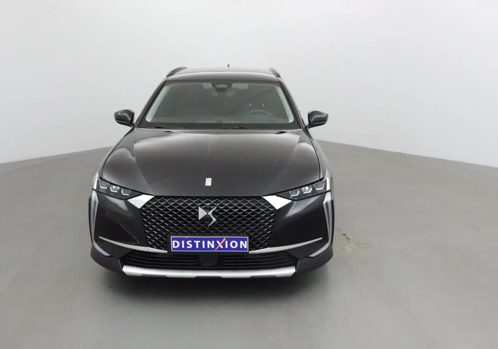 Vue frontale d'un DS4 noir 2022 avec calandre distinctive et éclairage LED anguleux dans un studio neutre.