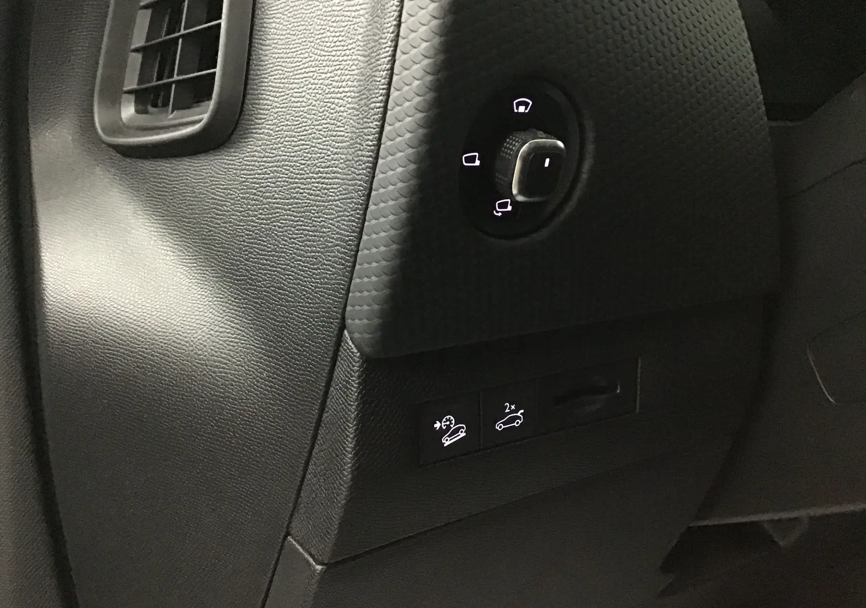 Détail du tableau de bord côté gauche du DS4 noir 2022, avec commandes éclairées pour rétroviseurs et aides à la conduite.