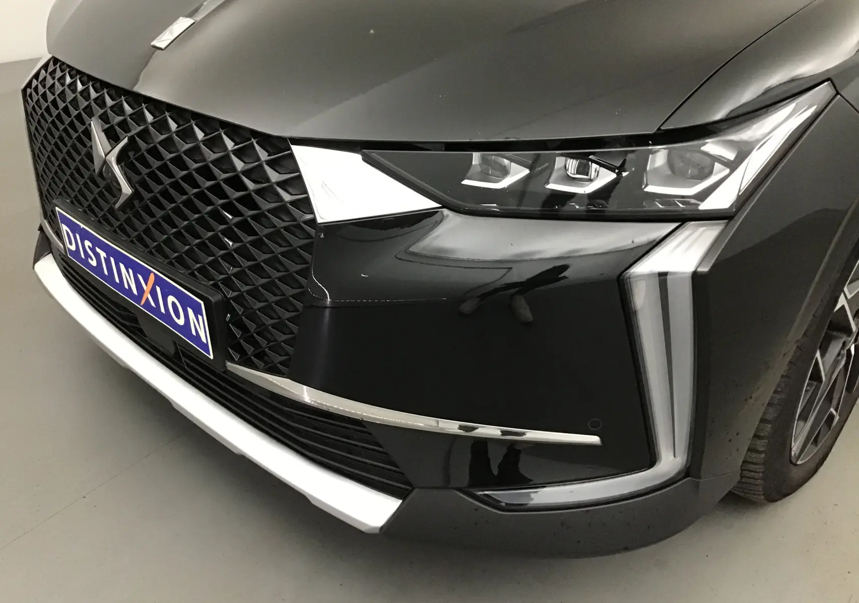 Gros plan sur l'avant droit noir brillant du DS4 2022 avec calandre DS et phares LED distinctifs.