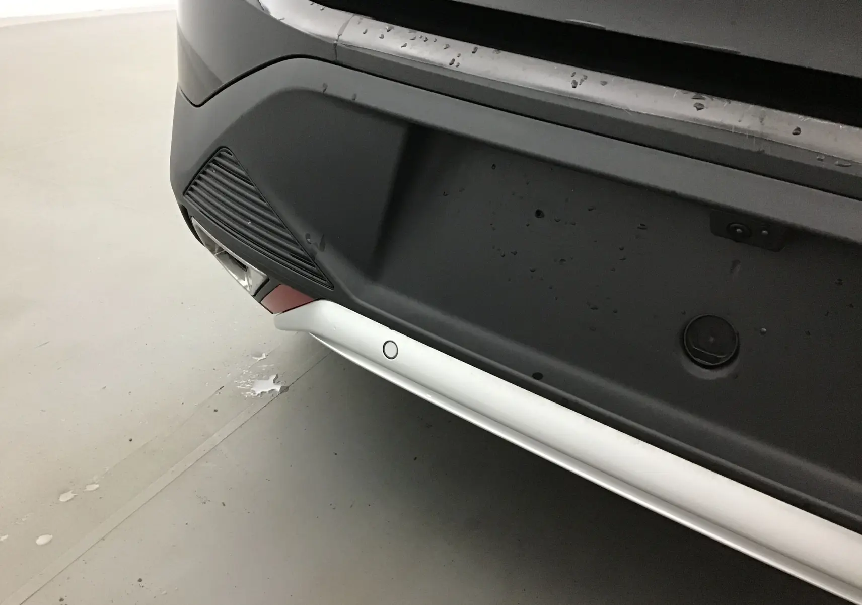 Gros plan sur le pare-chocs arrière noir du DS4 2022, mettant en valeur les capteurs de stationnement et la caméra de recul.