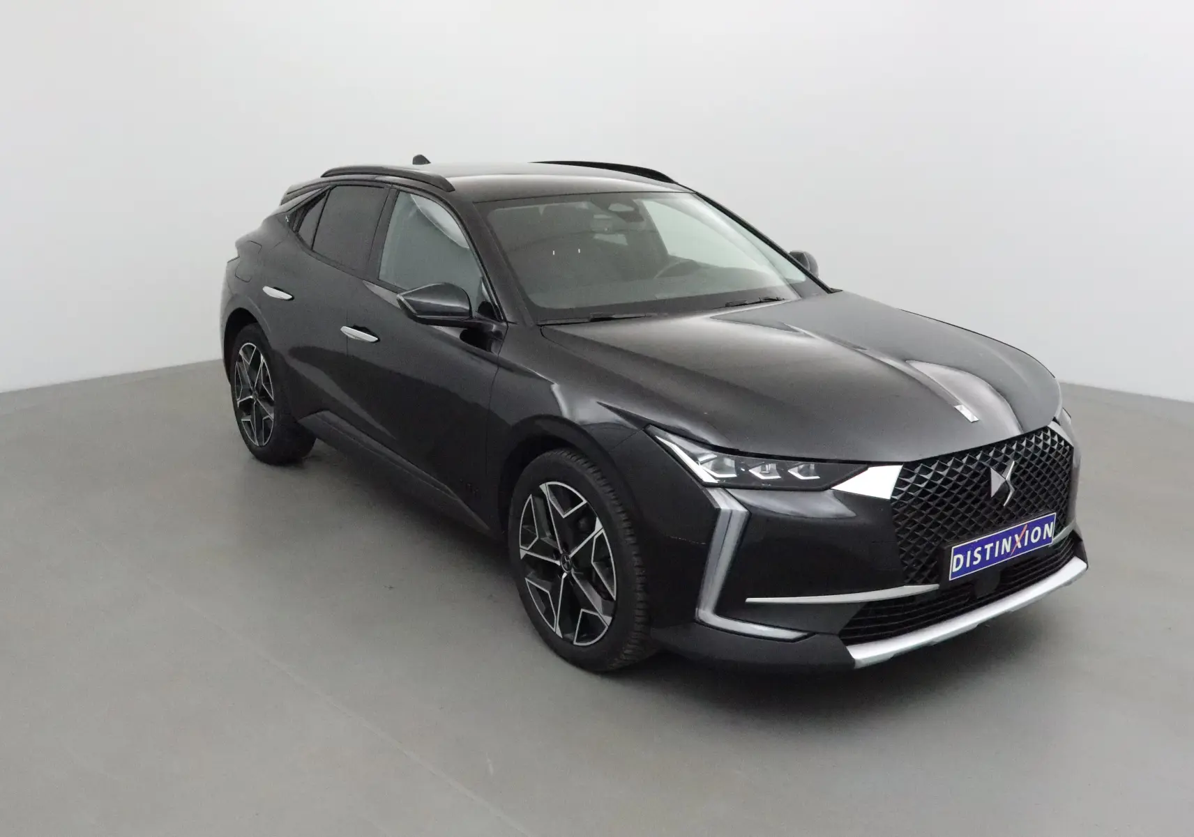 DS4 noir vue en 3/4 avant droit, mettant en valeur sa calandre distinctive et ses jantes alliage modernes.