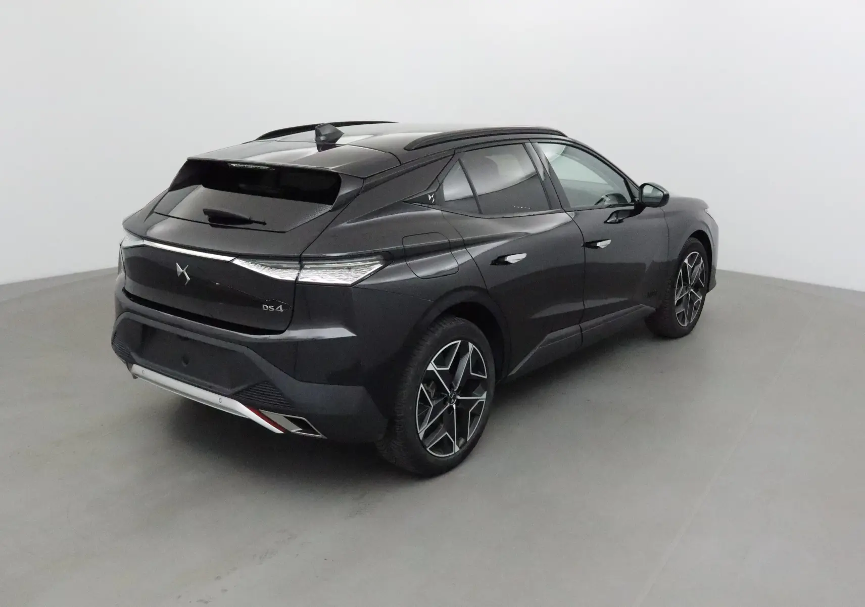 Vue 3/4 arrière droite du DS4 noir 2022 avec ses feux arrière effilés et jantes alliage distinctives.